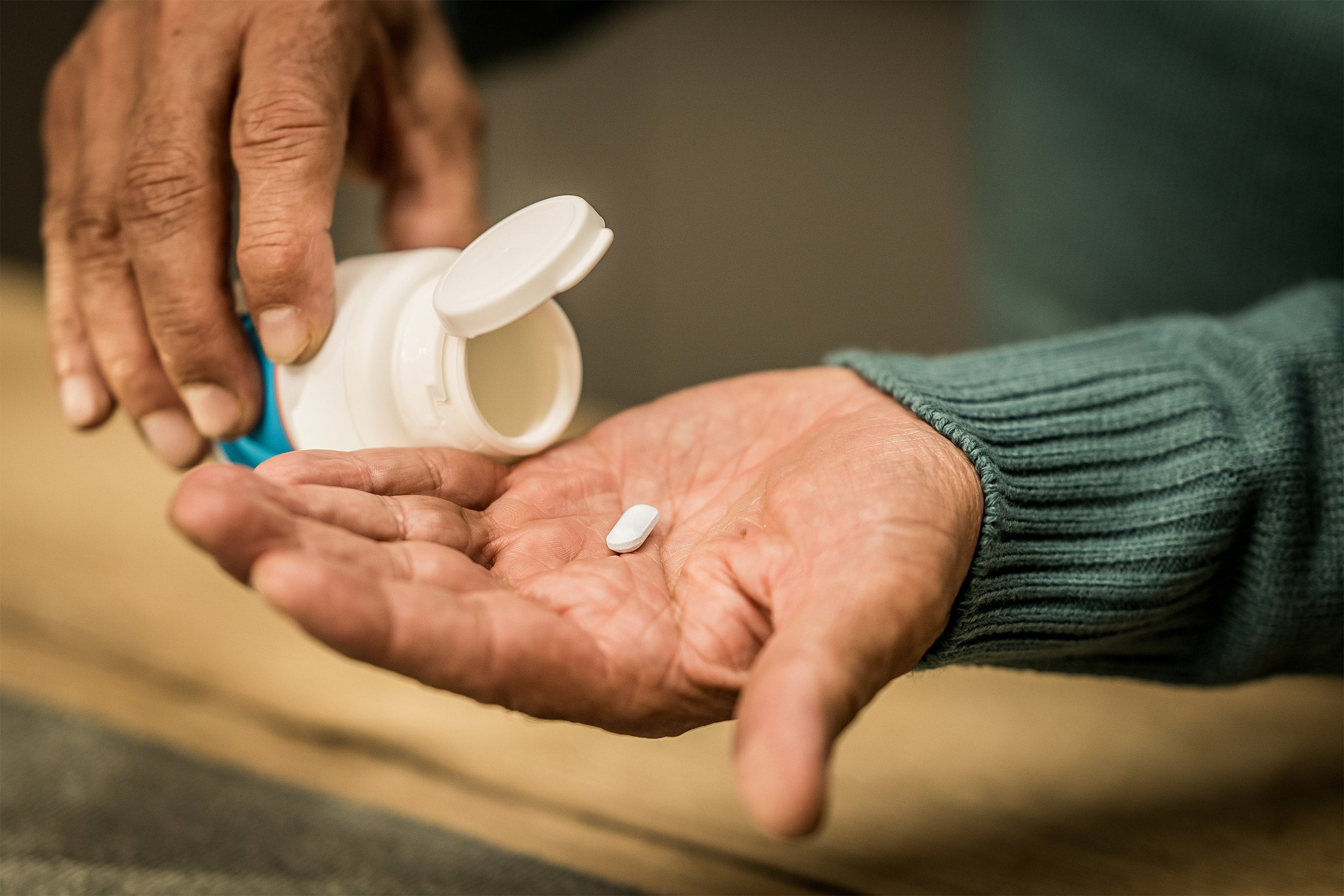 Man's hands holding pill bottle.